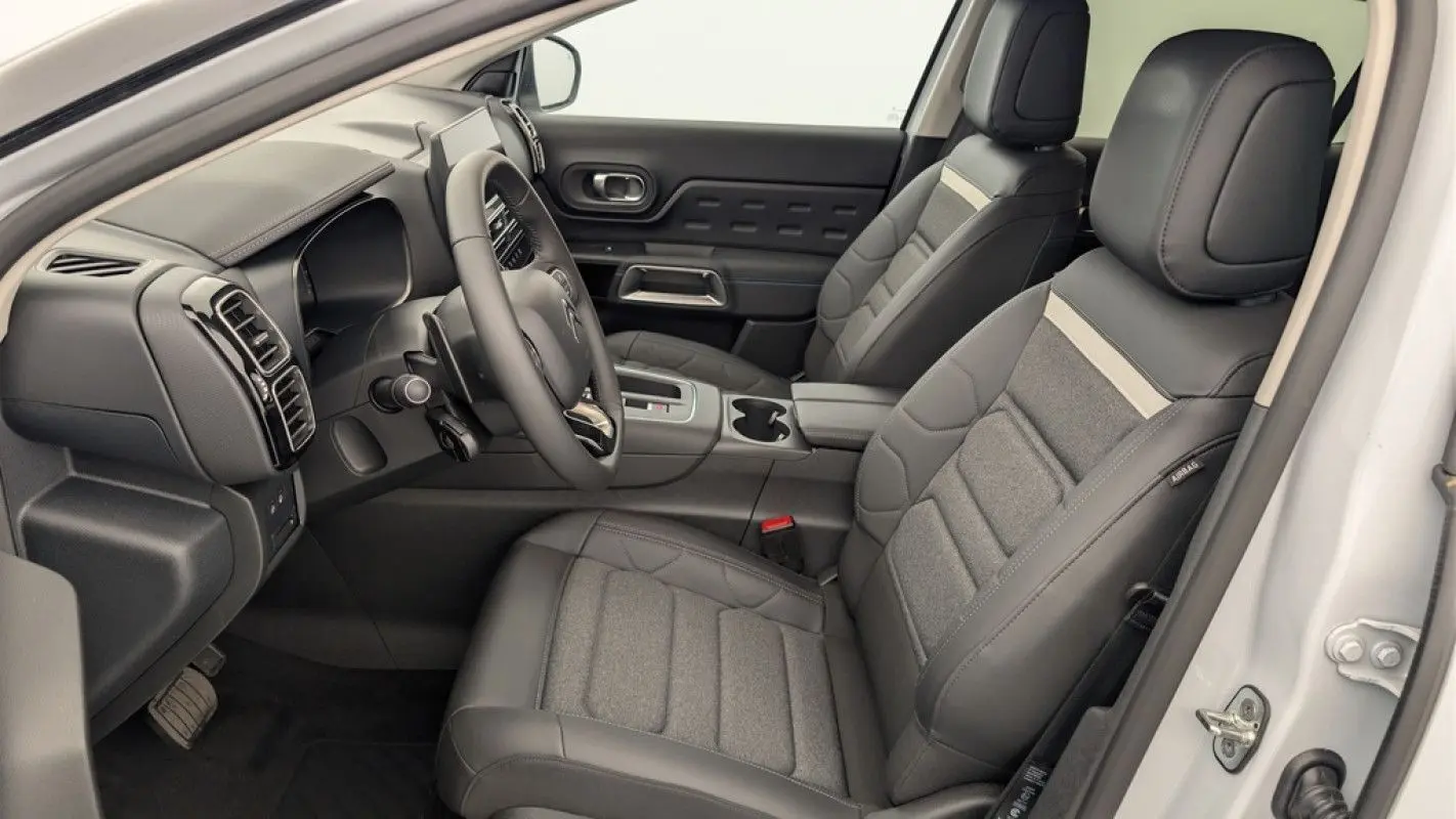 Intérieur avant droit du Citroën C5 Aircross blanc Okenite 2025, sièges en cuir et tissu gris avec console centrale moderne.
