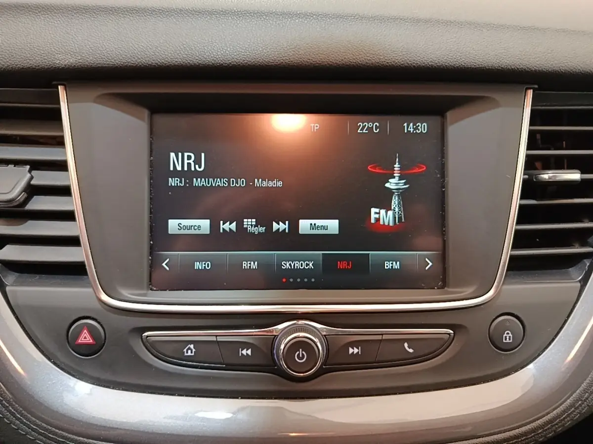 Écran tactile central de l’Opel Grandland X 1.5 Diesel 130 GS Line, affichant la radio NRJ en intérieur gris foncé.