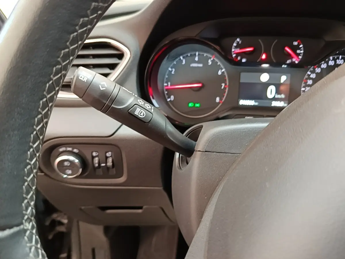 Vue rapprochée du tableau de bord et du volant cuir alu d’un Opel Grandland X gris foncé, avec commandes et compteurs visibles.