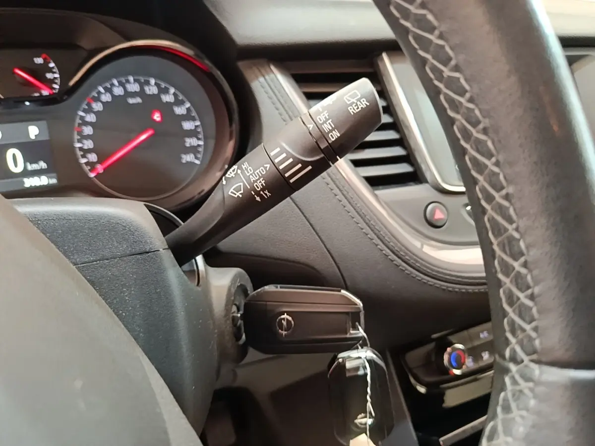 Vue rapprochée du tableau de bord et du volant cuir d’un Opel Grandland X gris foncé avec clé insérée.