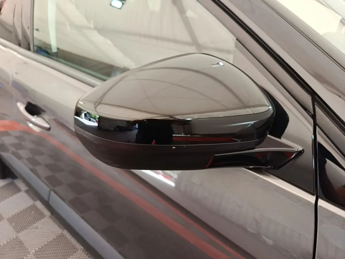 Rétroviseur côté gauche noir brillant d’un Opel Grandland X gris foncé, vue rapprochée sur la portière avant.