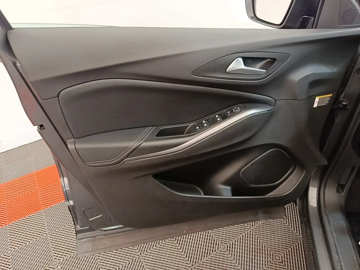 Vue intérieure côté gauche de la porte avant d’un Opel Grandland X gris foncé avec commandes électriques et haut-parleur intégré.