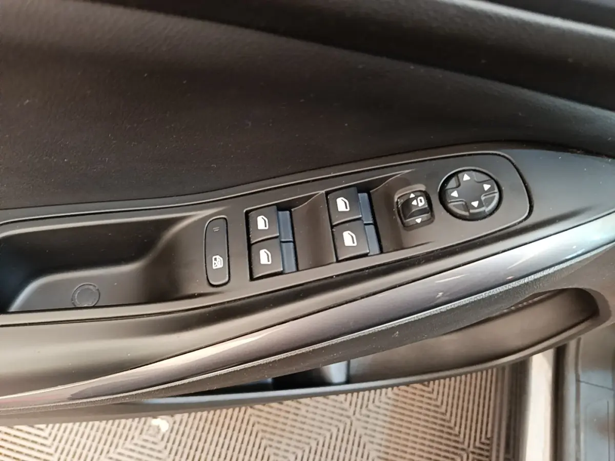 Gros plan sur les commandes de lève-vitres et rétroviseurs côté conducteur de l'Opel Grandland X gris foncé.