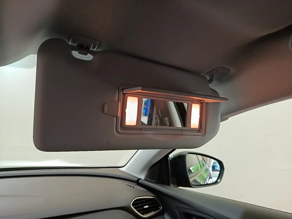 Détail intérieur du pare-soleil côté conducteur avec miroir éclairé dans un Opel Grandland X gris foncé.