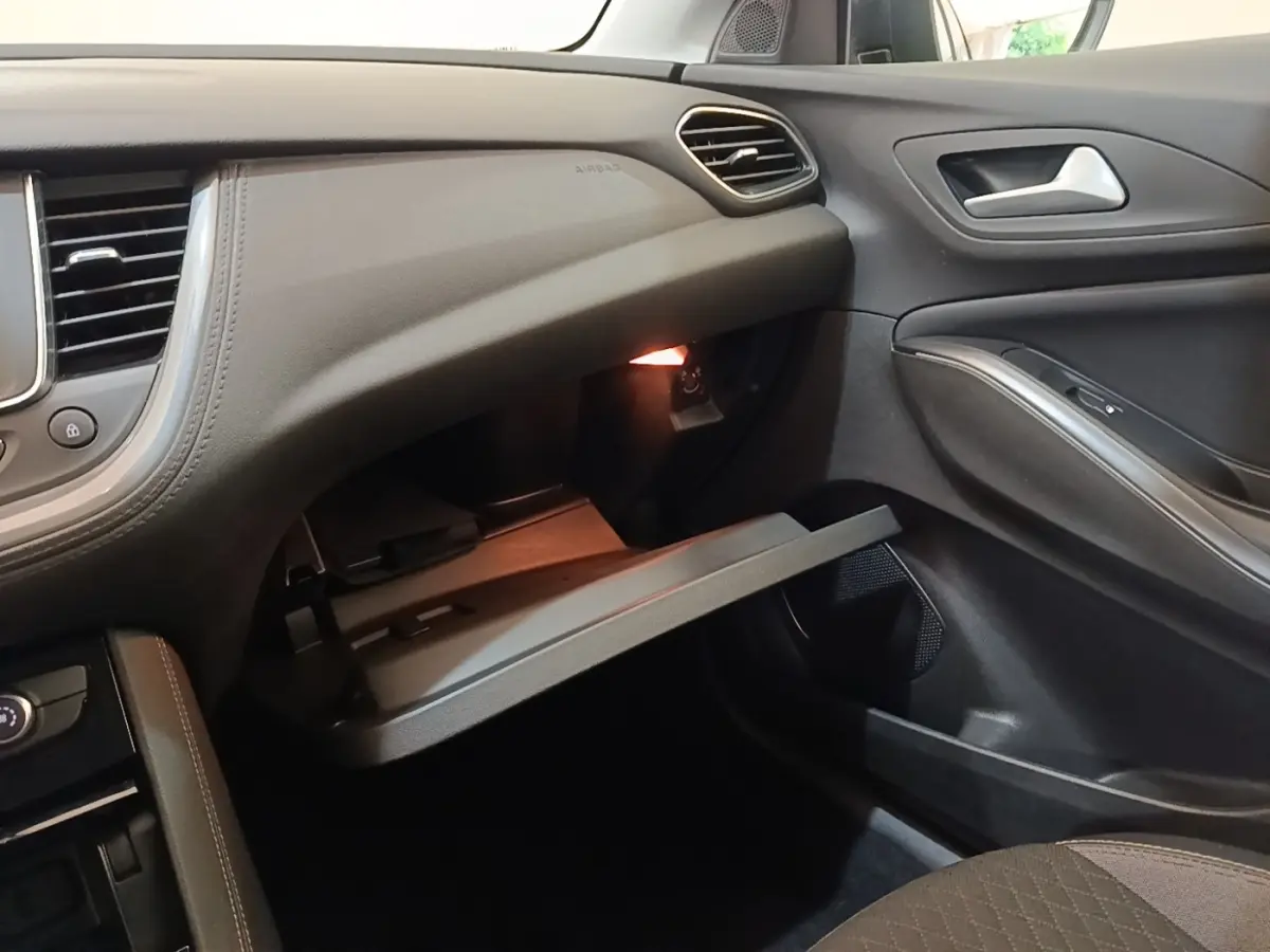 Intérieur côté passager de l’Opel Grandland X 2021, boîte à gants ouverte, garnitures noires et grises.