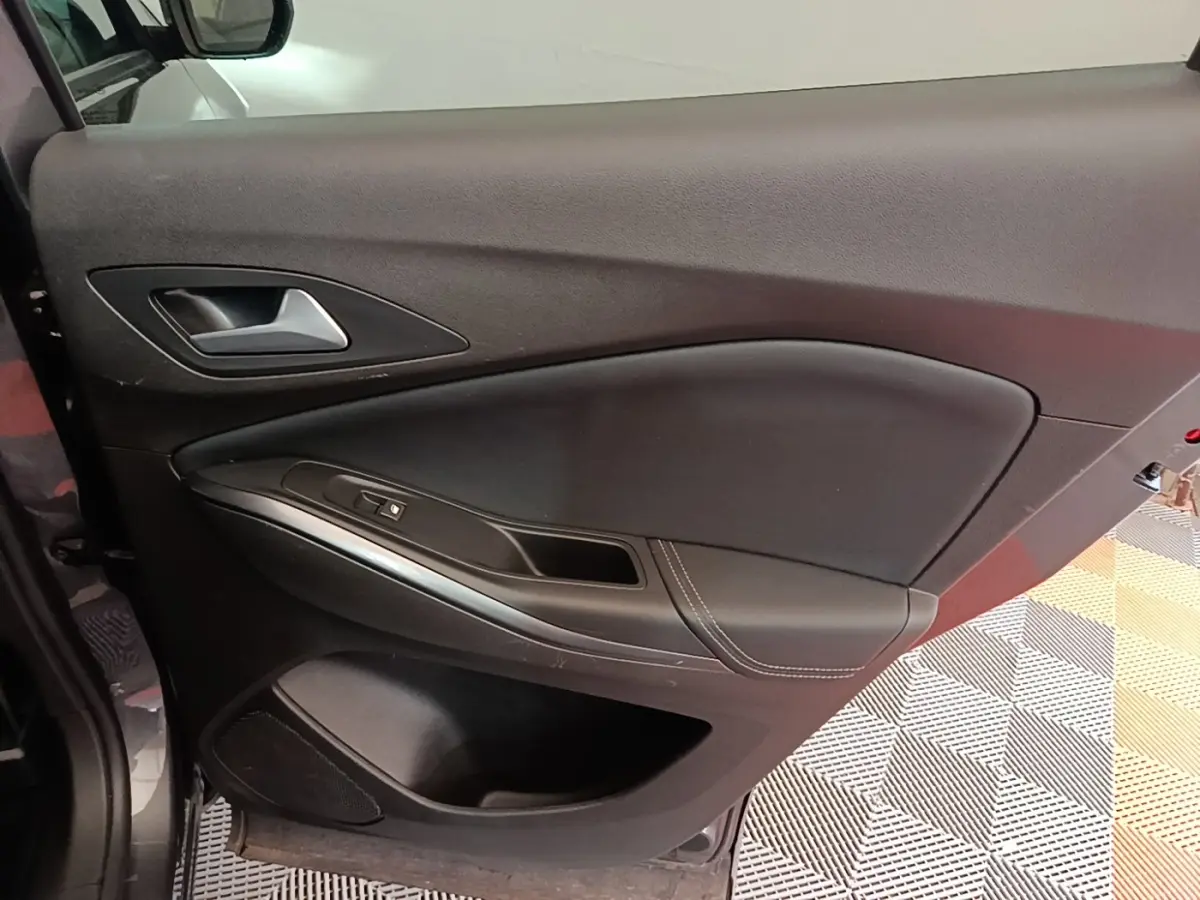 Intérieur de la porte côté gauche de l'Opel Grandland X gris foncé, avec poignée alu et commandes de vitre.