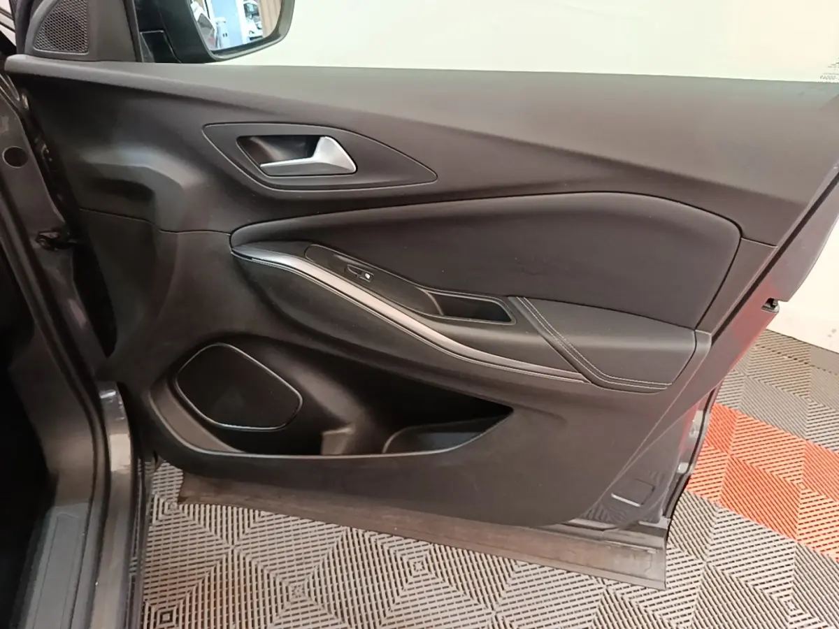 Vue intérieure du panneau de porte côté conducteur de l’Opel Grandland X gris foncé, avec poignée alu et commandes vitres.