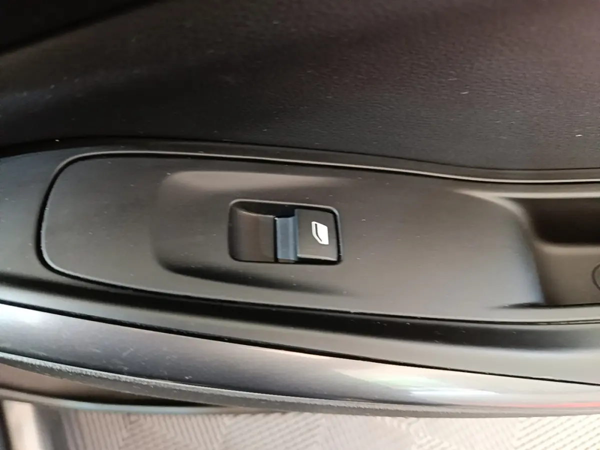 Gros plan sur le bouton de commande de lève-vitre côté porte intérieure d’un Opel Grandland X gris foncé.