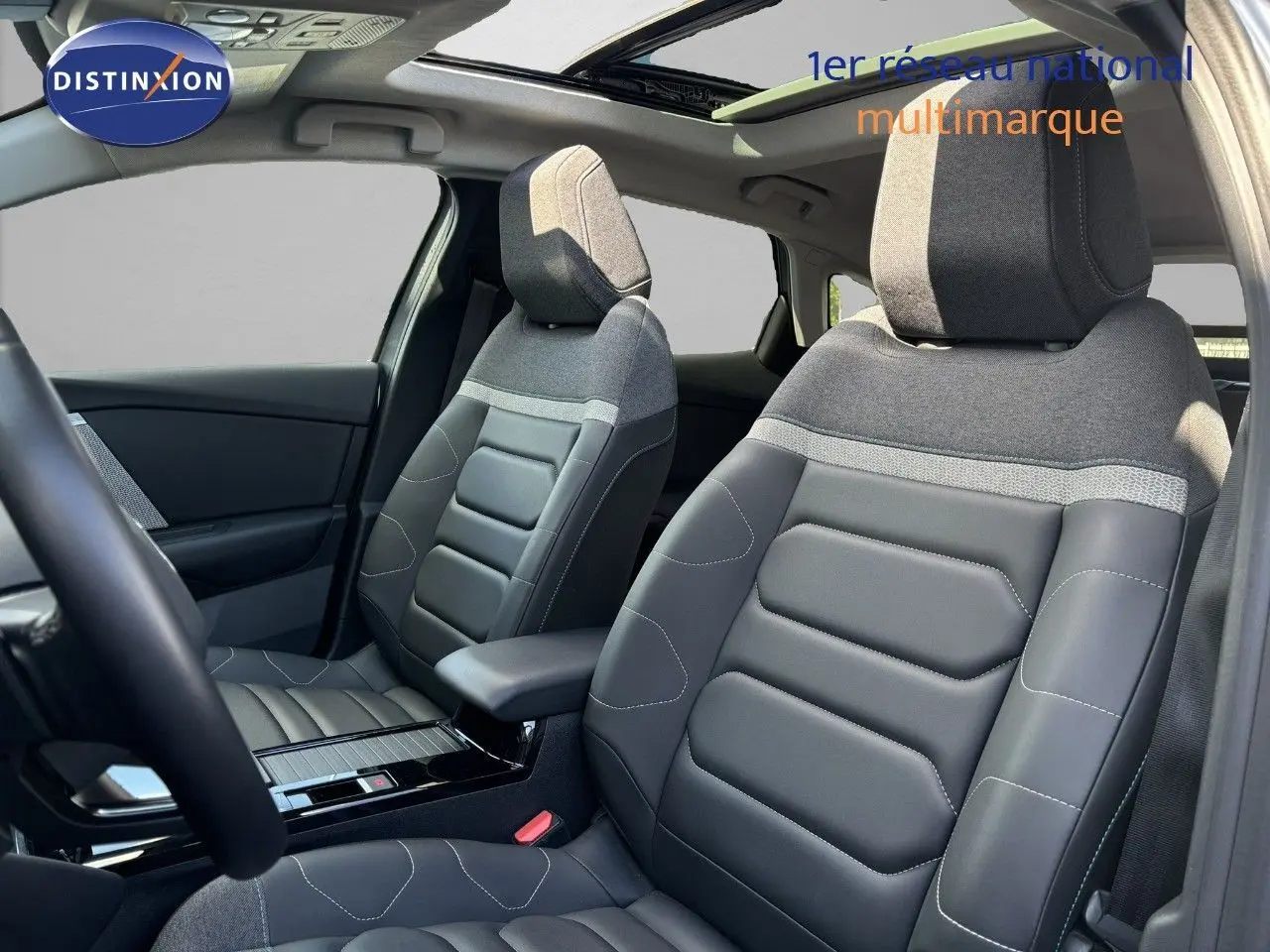 Intérieur de la Citroën C4 2022, vue côté gauche sur les sièges avant en tissu gris et cuir noir avec toit ouvrant.