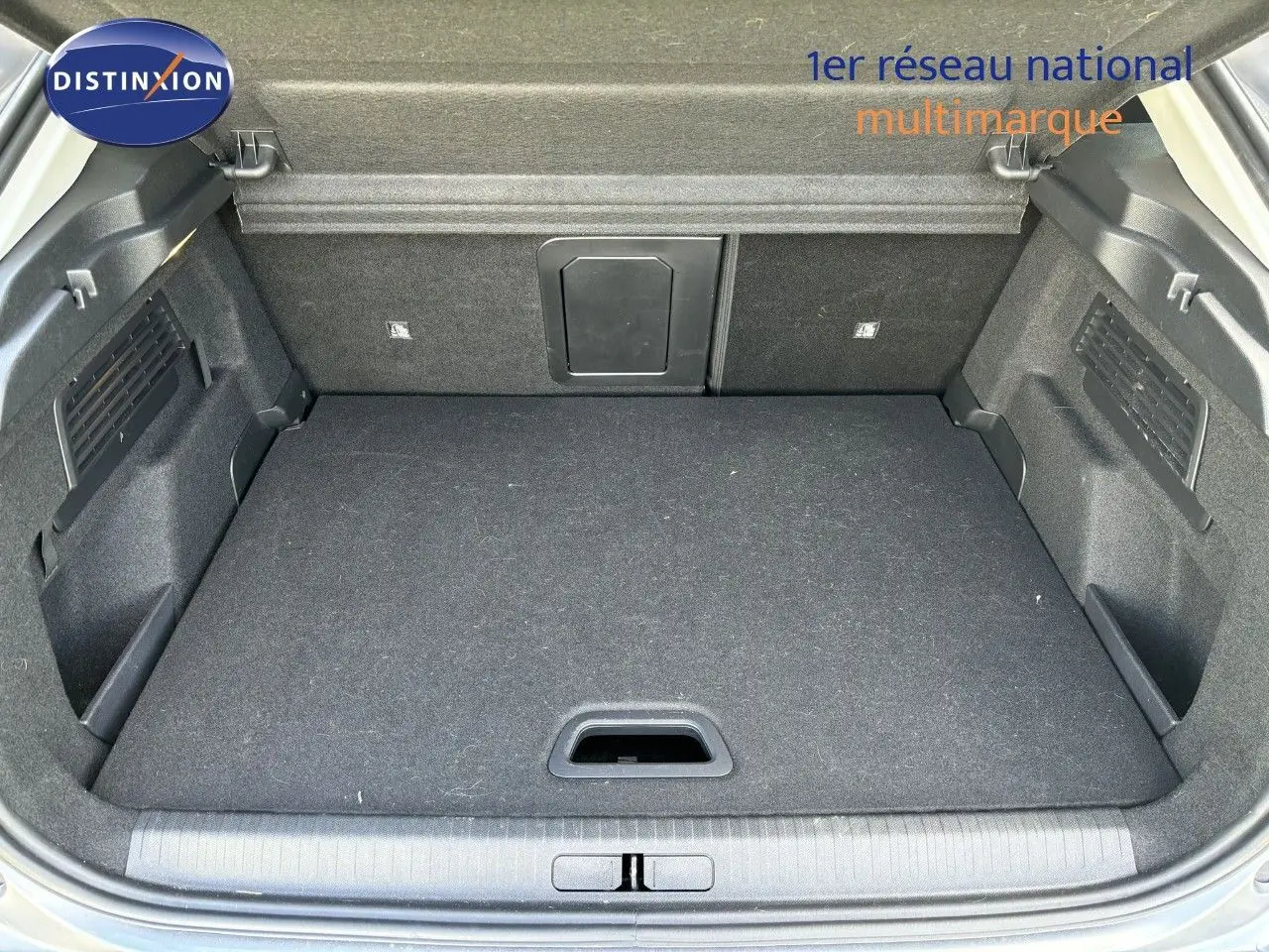 Coffre ouvert d'une Citroën C4 PureTech 130 Shine 2022 gris Artense, montrant un espace de chargement propre et bien agencé.