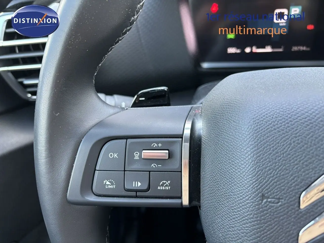 Gros plan sur les commandes au volant à gauche d'une Citroën C4 gris Artense 2022 avec régulateur et assistant de conduite.