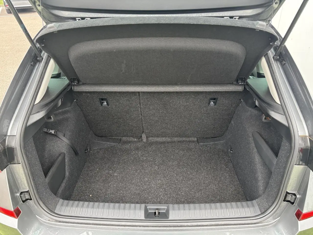Coffre ouvert vu de l'arrière d'un Skoda Kamiq gris graphite métallisé, intérieur en tissu noir.