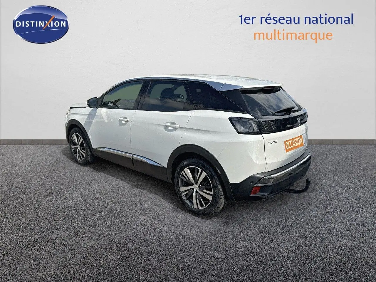 Peugeot 3008 blanc nacré en 3/4 arrière côté gauche, avec attelage et jantes bi-ton visibles.