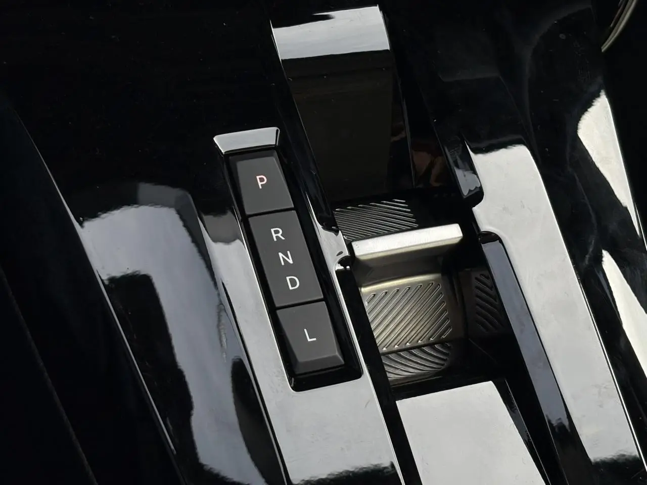 Gros plan sur la console centrale noire brillante avec sélecteur de boîte auto à boutons P, R, N, D, L du Citroën C3 Aircross.