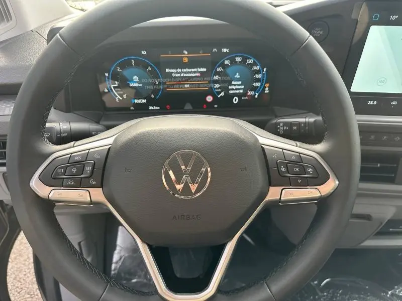 Vue rapprochée du volant cuir multifonction gris du Volkswagen Transporter Procab 2025 avec tableau de bord numérique.