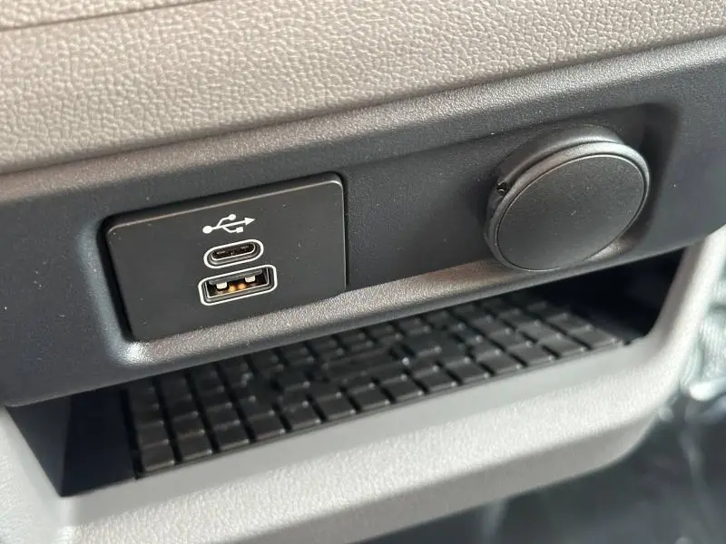 Gros plan sur les ports USB-C et USB-A noirs intégrés dans la console grise du Volkswagen Transporter FGN Procab 2025.