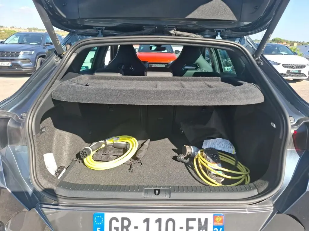 Coffre ouvert vu de l'arrière d'un CUPRA Formentor gris 2023 avec câbles de recharge hybride visibles.