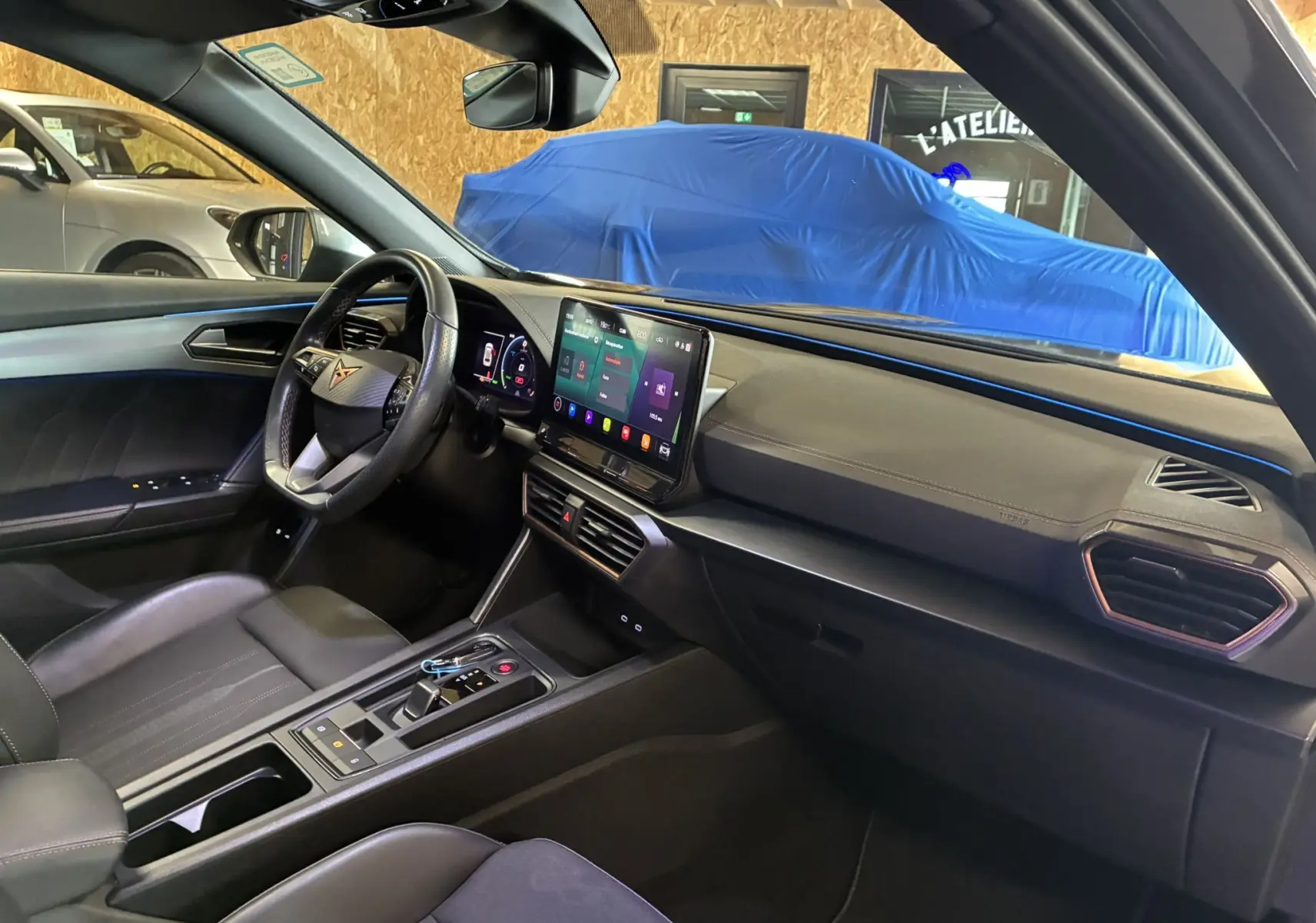 Intérieur de la CUPRA Formentor 1.4 e-Hybrid 2023 vu côté passager, avec volant cuir et écran tactile central.