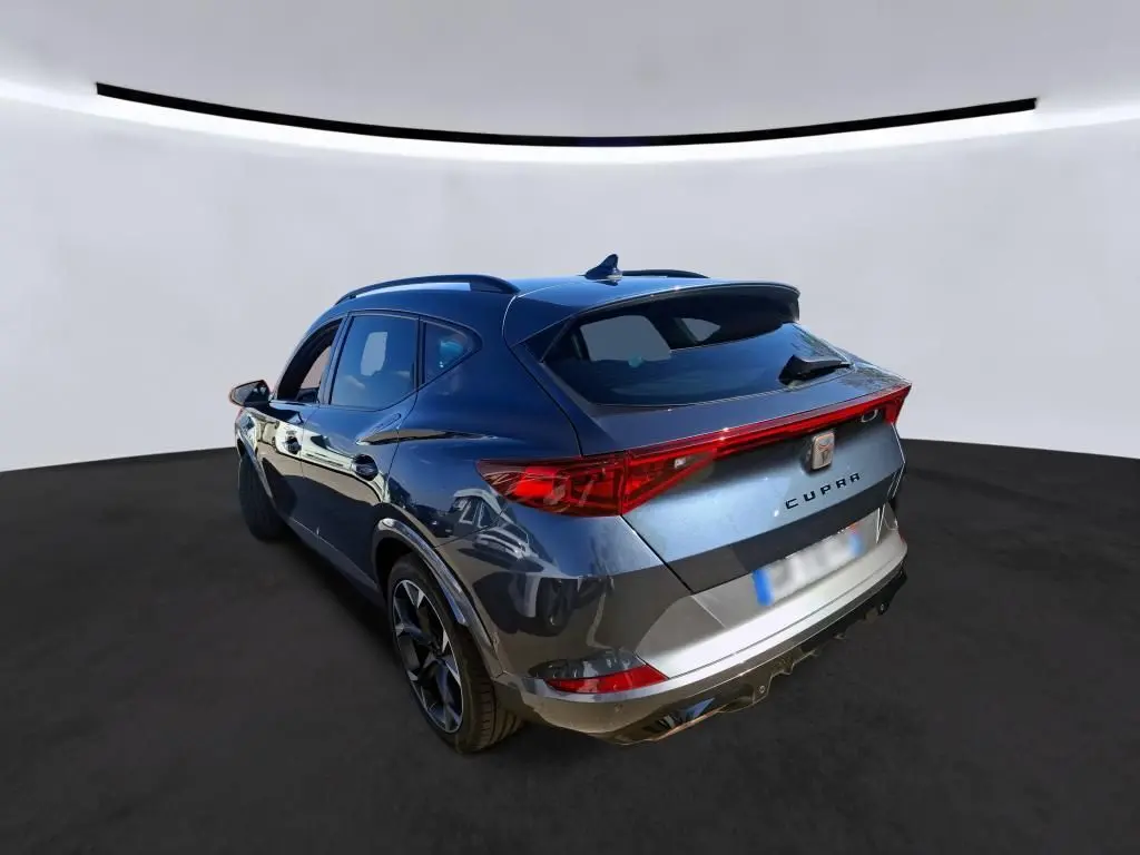 Vue 3/4 arrière droite d'un SUV CUPRA Formentor gris avec feux arrière LED et toit avec antenne requin.
