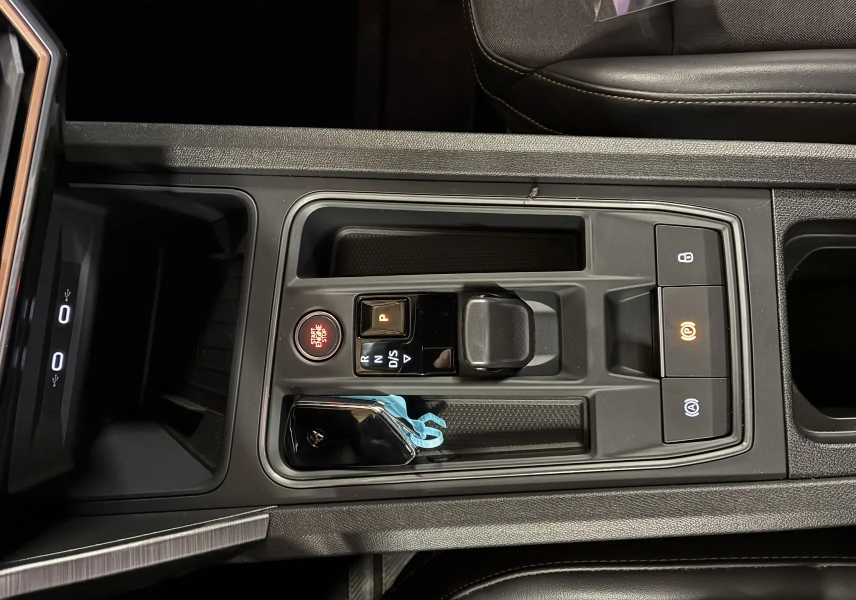 Vue plongeante sur la console centrale noire du CUPRA Formentor 1.4 E-HYBRID avec bouton start/stop et levier de vitesse compact.