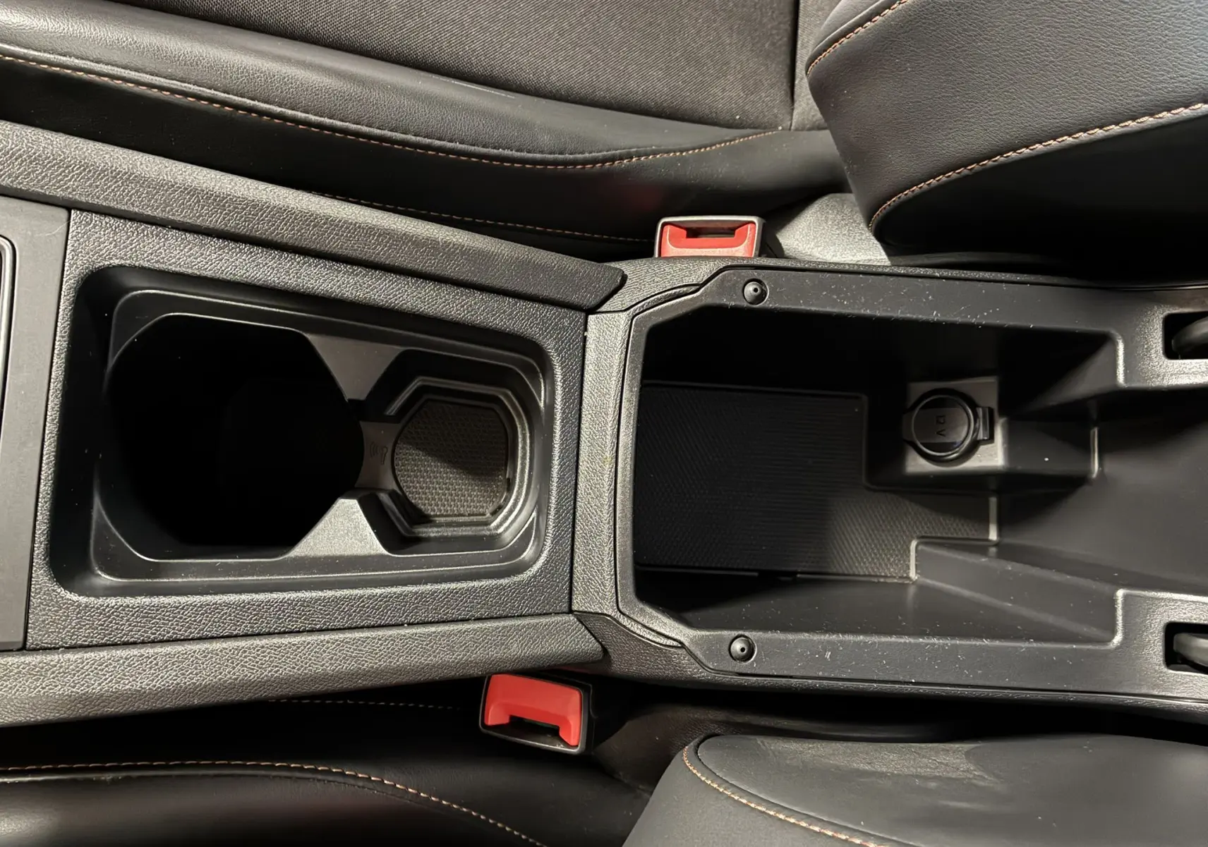 Gros plan sur la console centrale noire avec porte-gobelets et prise 12V du CUPRA Formentor gris 2023.