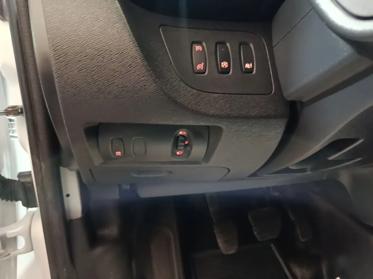 Détail intérieur côté conducteur du Renault Kangoo blanc 2020, montrant les commandes des rétroviseurs et aides à la conduite.