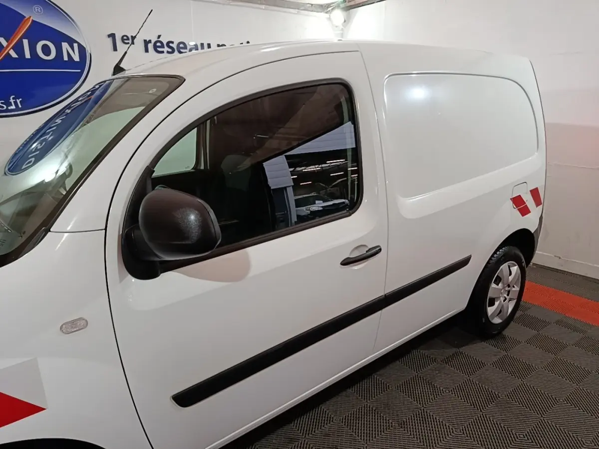 Vue de profil droit du Renault Kangoo Extra R-Link blanc avec marquages rouges sur la porte arrière.