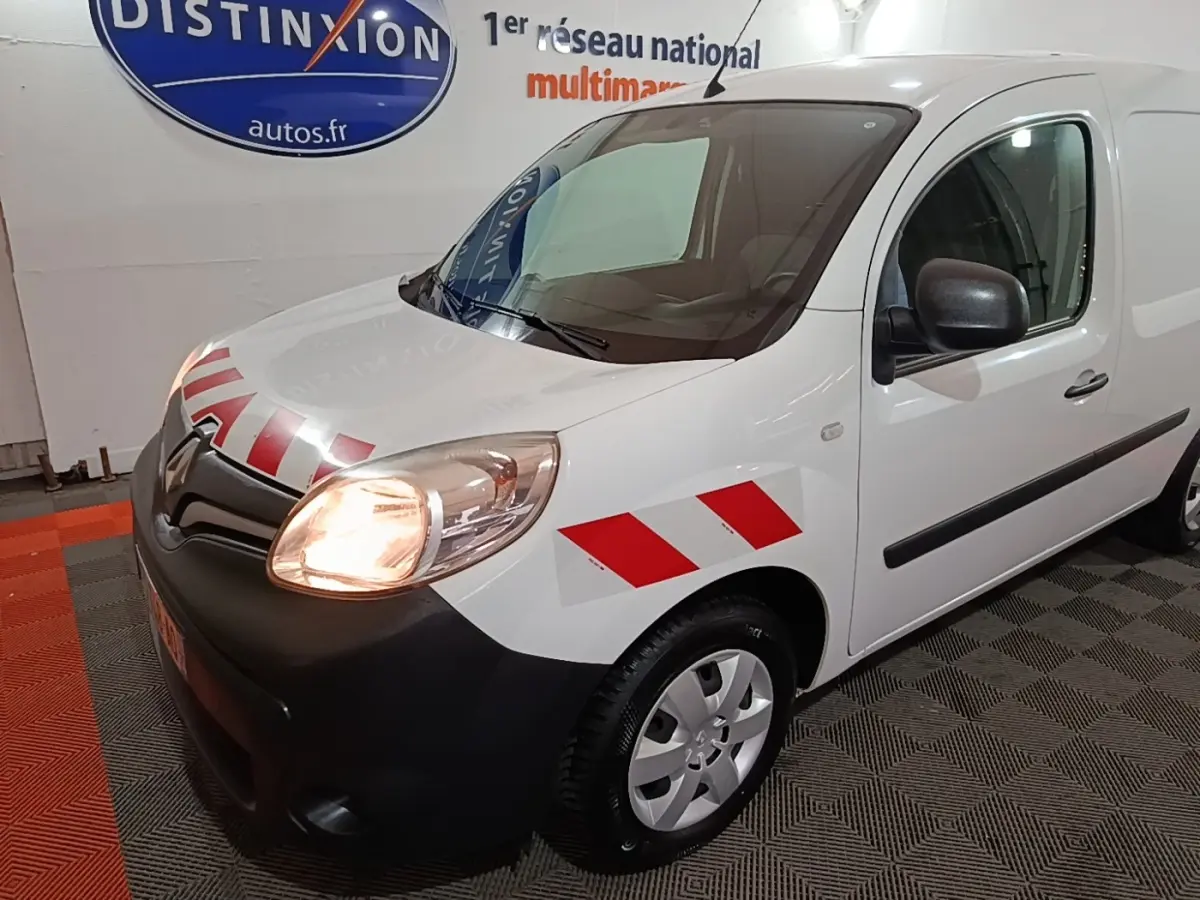 Renault Kangoo blanc vue 3/4 avant droit avec bandes rouges diagonales sur l'aile et capot noir mat.