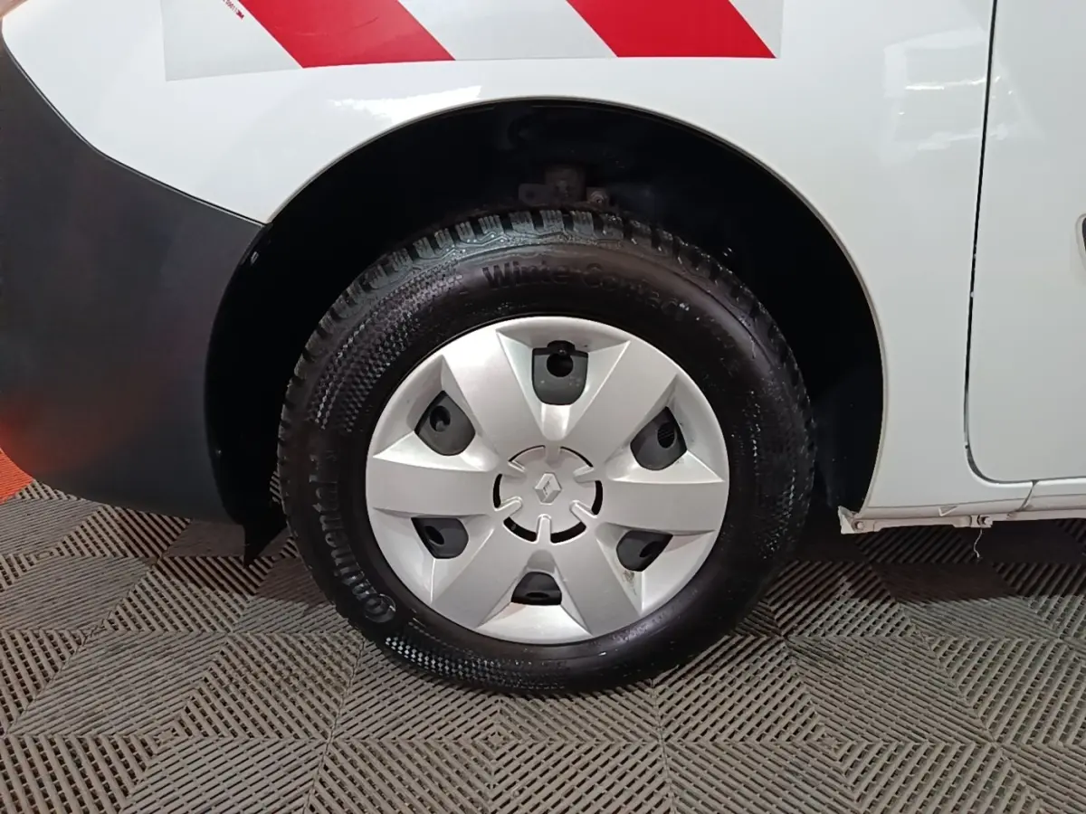 Gros plan sur la roue arrière droite blanche d’un Renault Kangoo Extra R-Link 2020 avec enjoliveur argenté et pneu hiver.