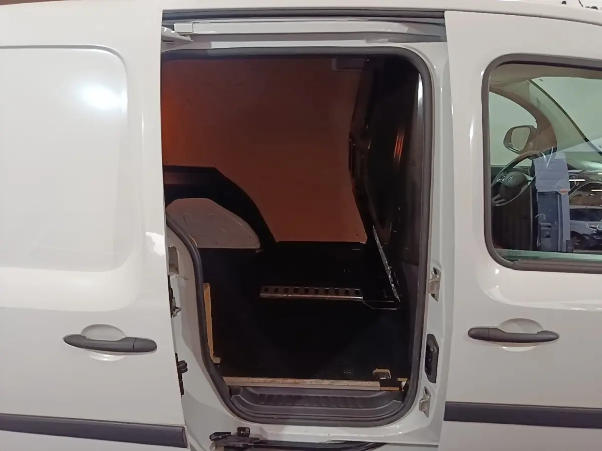 Vue latérale gauche d’un Renault Kangoo blanc 2020 avec porte coulissante ouverte montrant l’espace de chargement vide.