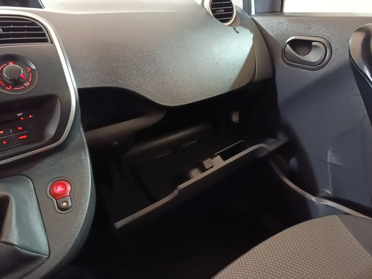 Intérieur du Renault Kangoo 2020 blanc, vue côté passager sur la boîte à gants ouverte et tableau de bord noir.