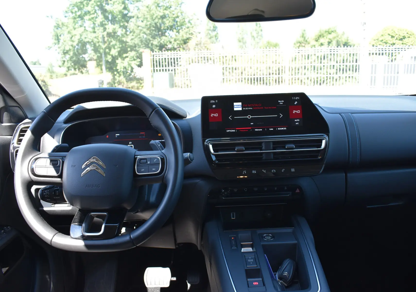 Vue intérieure avant du Citroën C5 Aircross 2024, tableau de bord noir avec écran tactile central et volant multifonction.