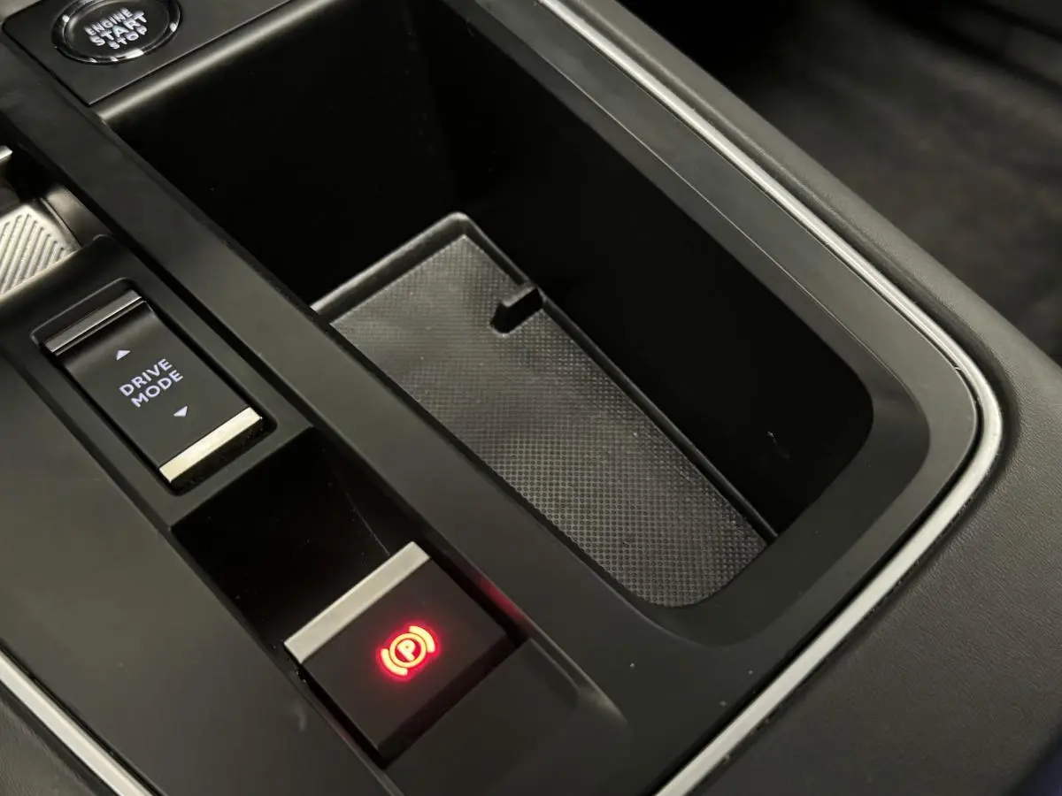 Gros plan sur la console centrale noire avec bouton frein à main électronique allumé et commande Drive Mode du Citroën C5 Aircross.