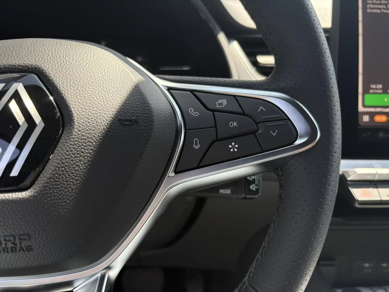 Gros plan sur le volant cuir multifonctions du Renault Captur noir étoile, avec commandes intégrées et tableau de bord numérique visible.