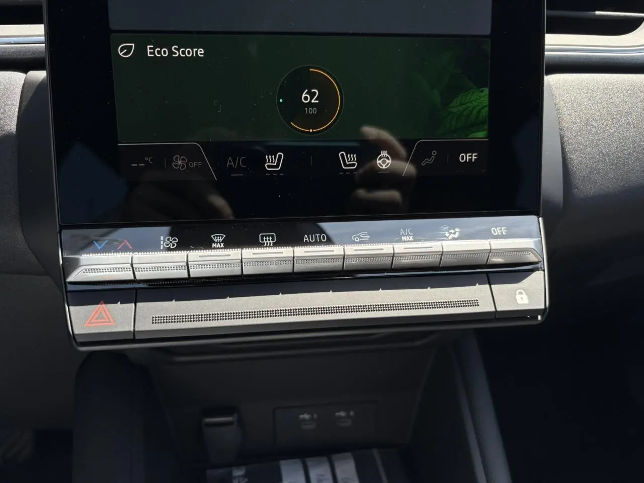 Gros plan sur la console centrale tactile du Renault Captur noir étoile 2025, affichant l'Eco Score et commandes climatisation.