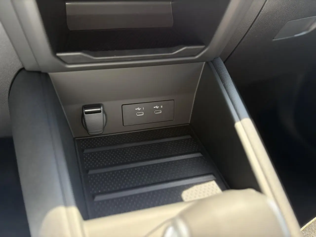 Gros plan sur la console centrale noire du Renault Captur 2025, montrant les ports USB-C doubles et un allume-cigare.