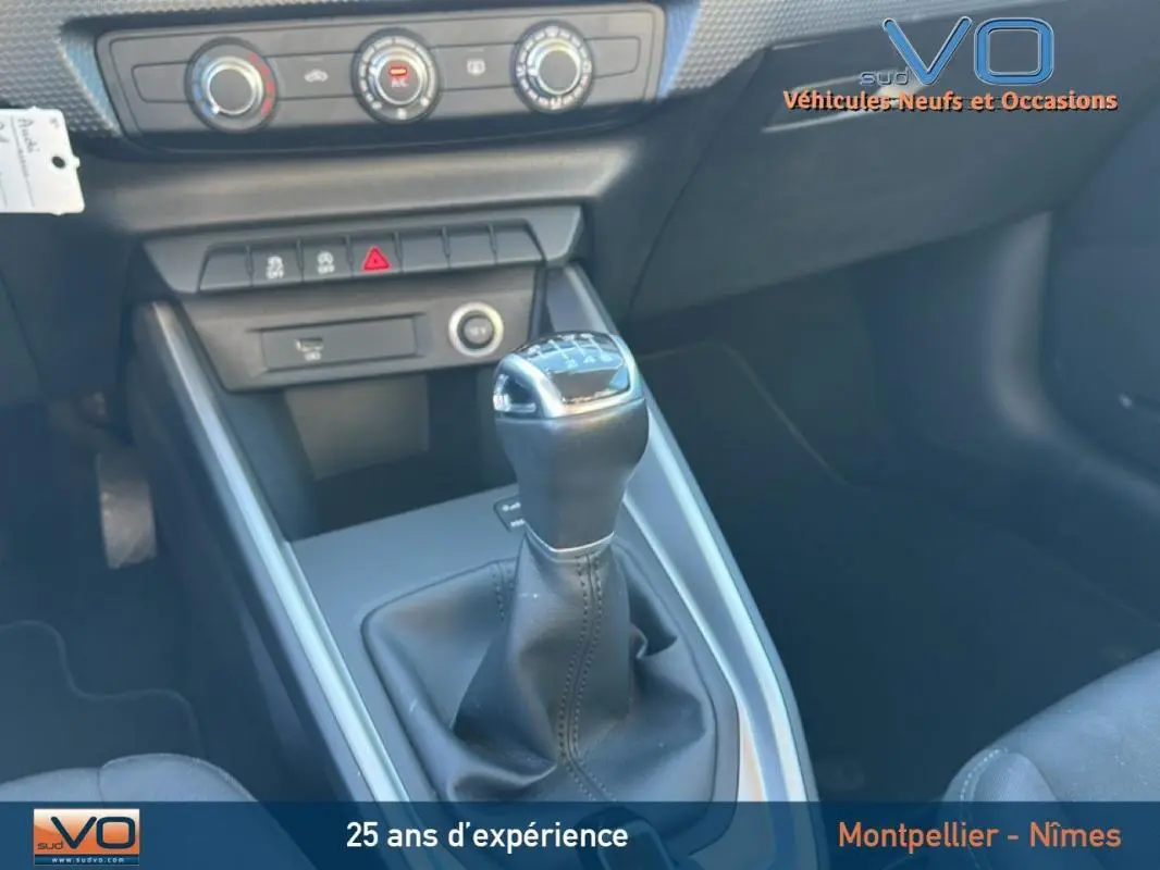 Le levier de vitesses manuel de l'Audi A1 Sportback 30 TFSI gris foncé, avec console centrale et commandes de climatisation visibles.