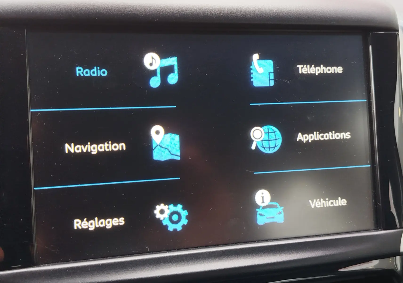 Écran tactile central de la Peugeot 208 affichant les options Radio, Navigation, Téléphone, Applications, Réglages et Véhicule.