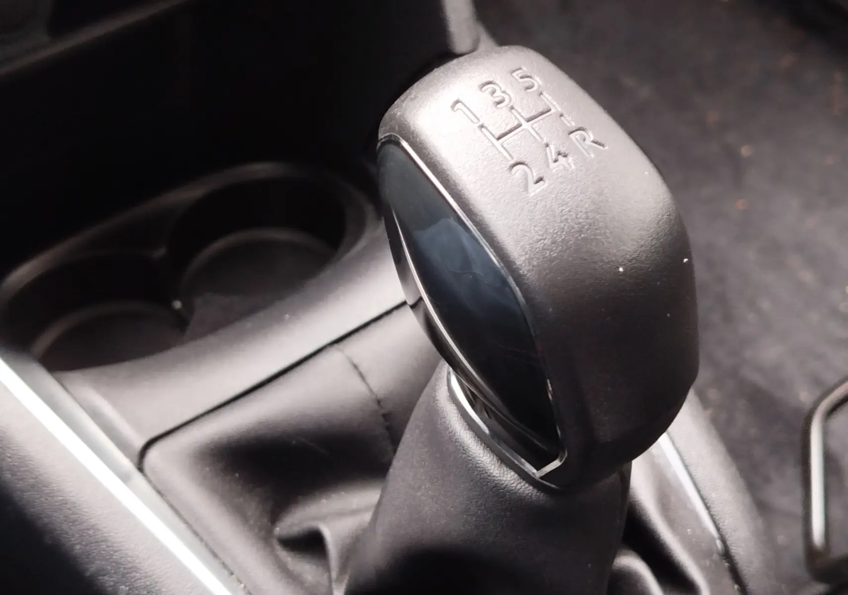 Gros plan sur le levier de vitesses manuel noir de la Peugeot 208 1.5 BlueHDi, montrant les rapports gravés.