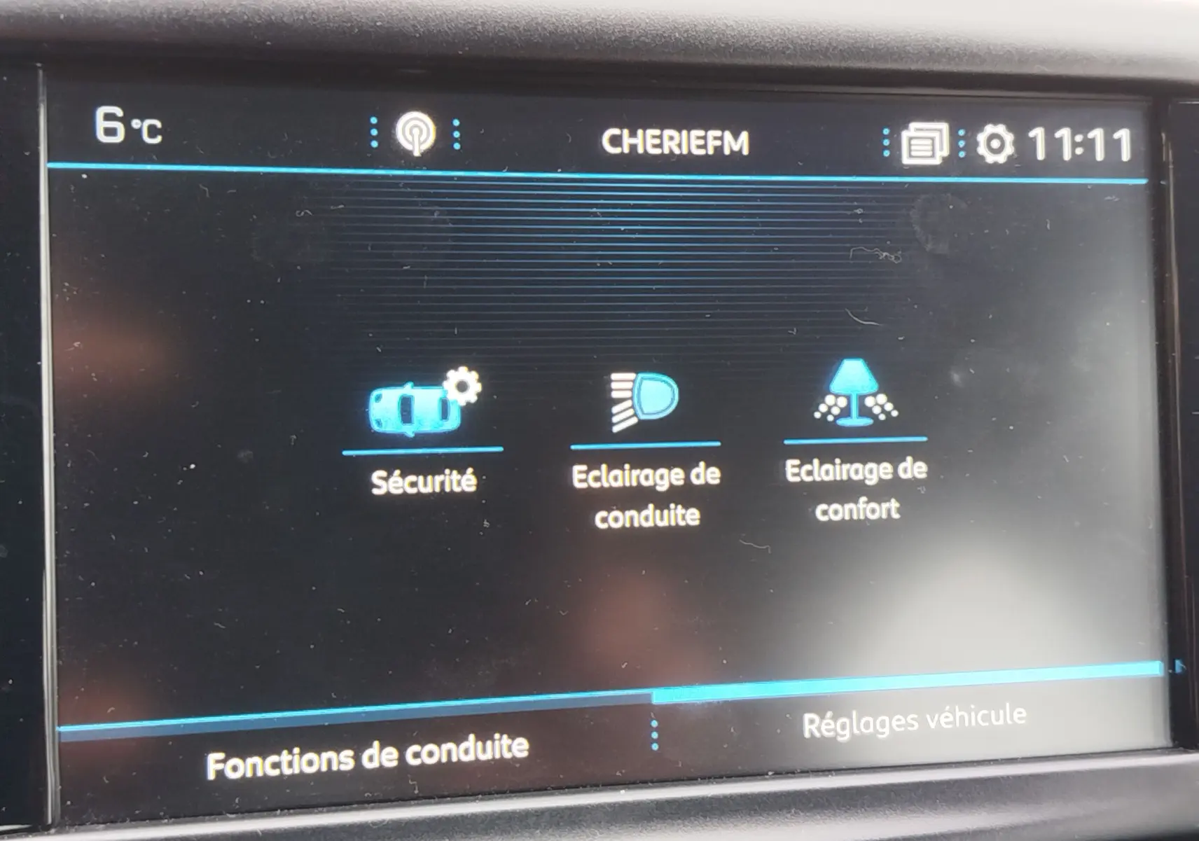 Écran tactile intérieur de la Peugeot 208 noir Perla Nera 2019 affichant les réglages de conduite et éclairage.