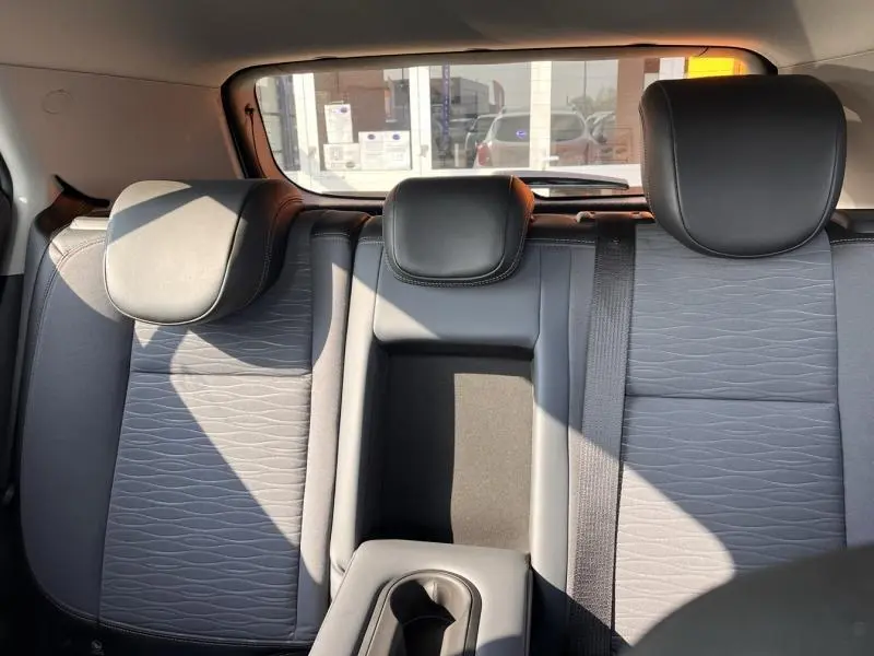 Vue arrière intérieure sur la banquette arrière grise avec appuie-têtes et accoudoir central du Opel Mokka blanc Glacier 2015.