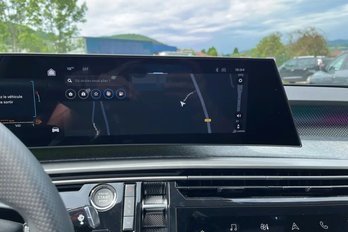 Vue intérieure du tableau de bord du Peugeot 5008 Hybrid 2025 avec écran tactile de navigation et commandes centrales.