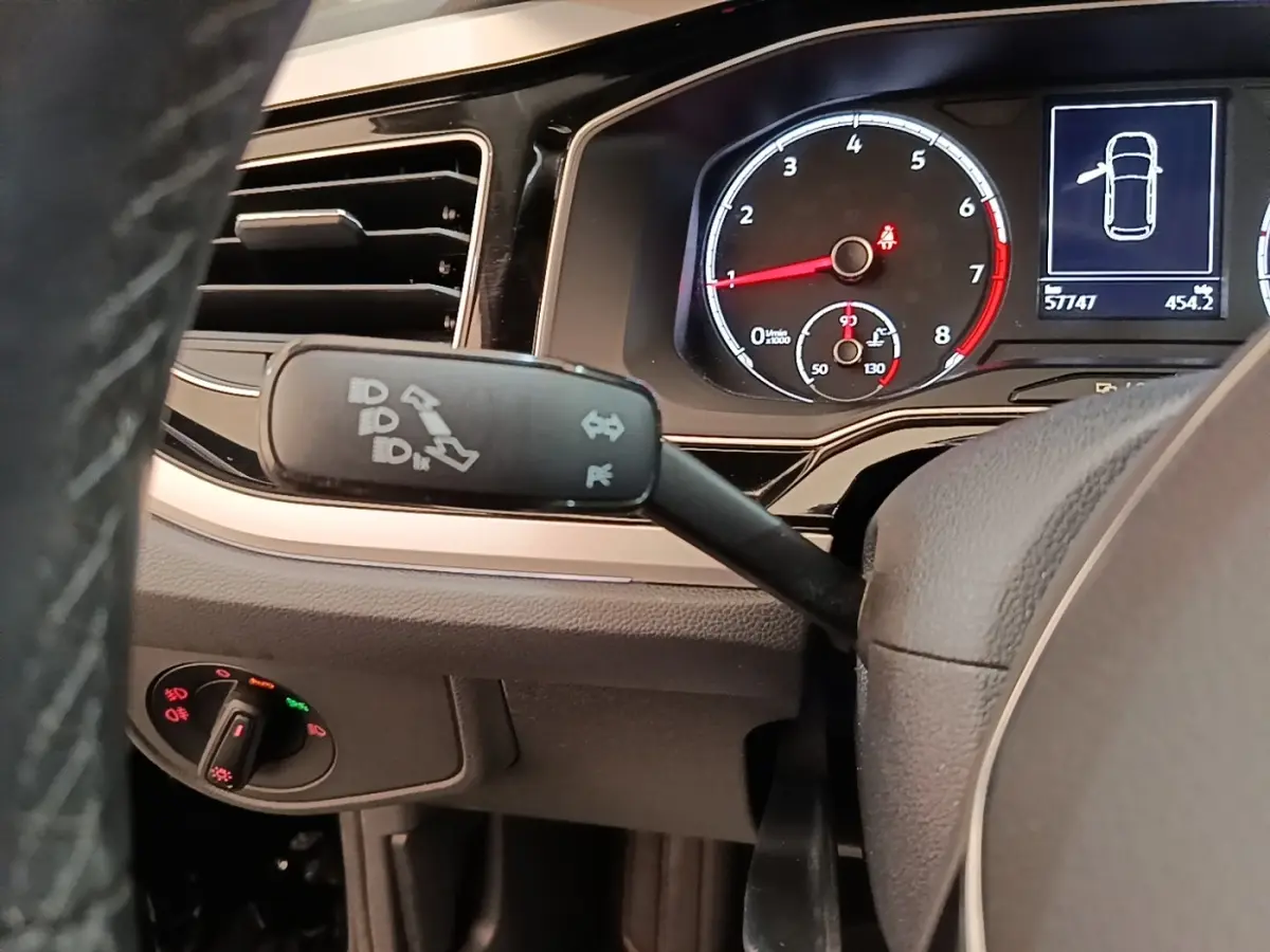 Vue rapprochée du tableau de bord et du volant noir d’une Volkswagen Polo 1.0 TSI 115 DSG7 Carat avec commandes et compte-tours visibles.
