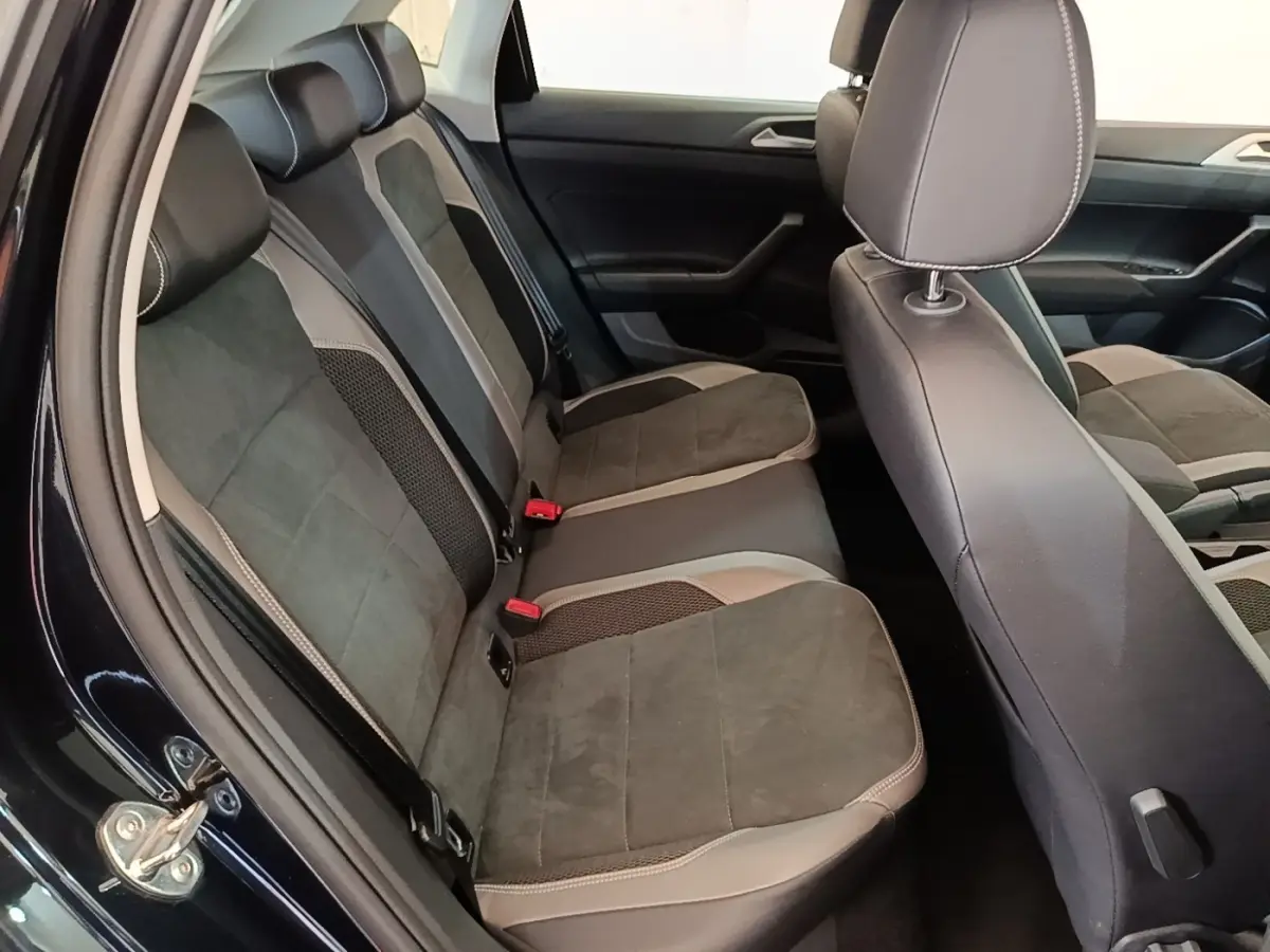 Vue intérieure côté gauche montrant la banquette arrière en tissu gris et noir de la Volkswagen Polo noire 2020.