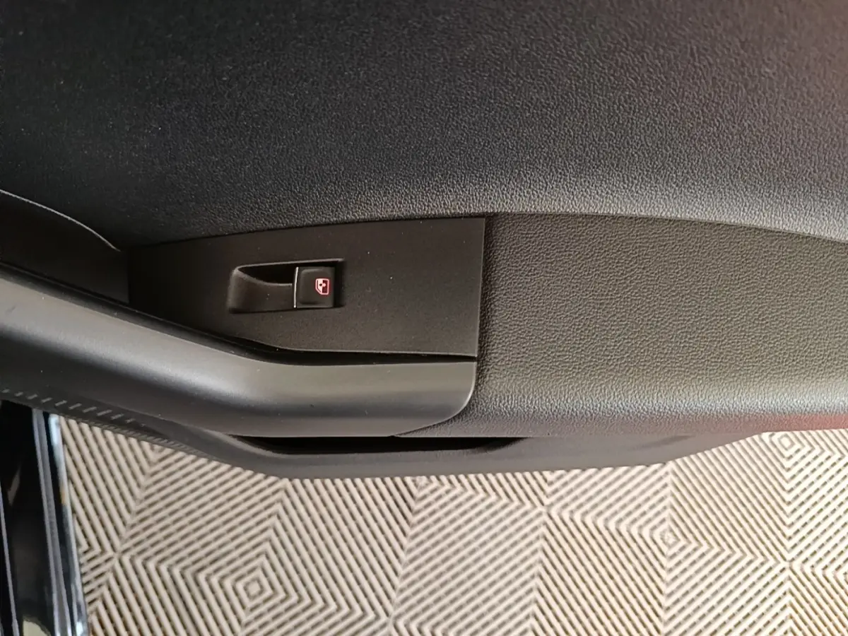 Détail de la poignée intérieure de porte côté conducteur de la Volkswagen Polo noire, avec bouton de verrouillage.
