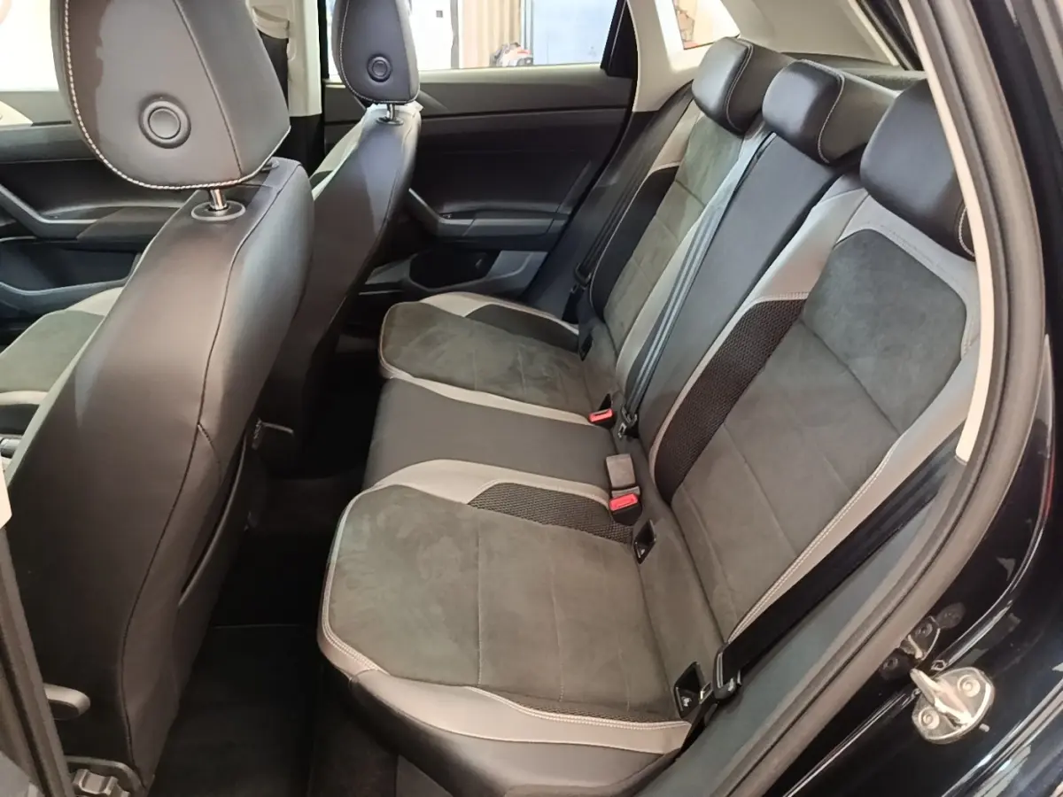 Vue intérieure côté droit sur la banquette arrière en tissu gris et cuir noir de la Volkswagen Polo noire 2020.