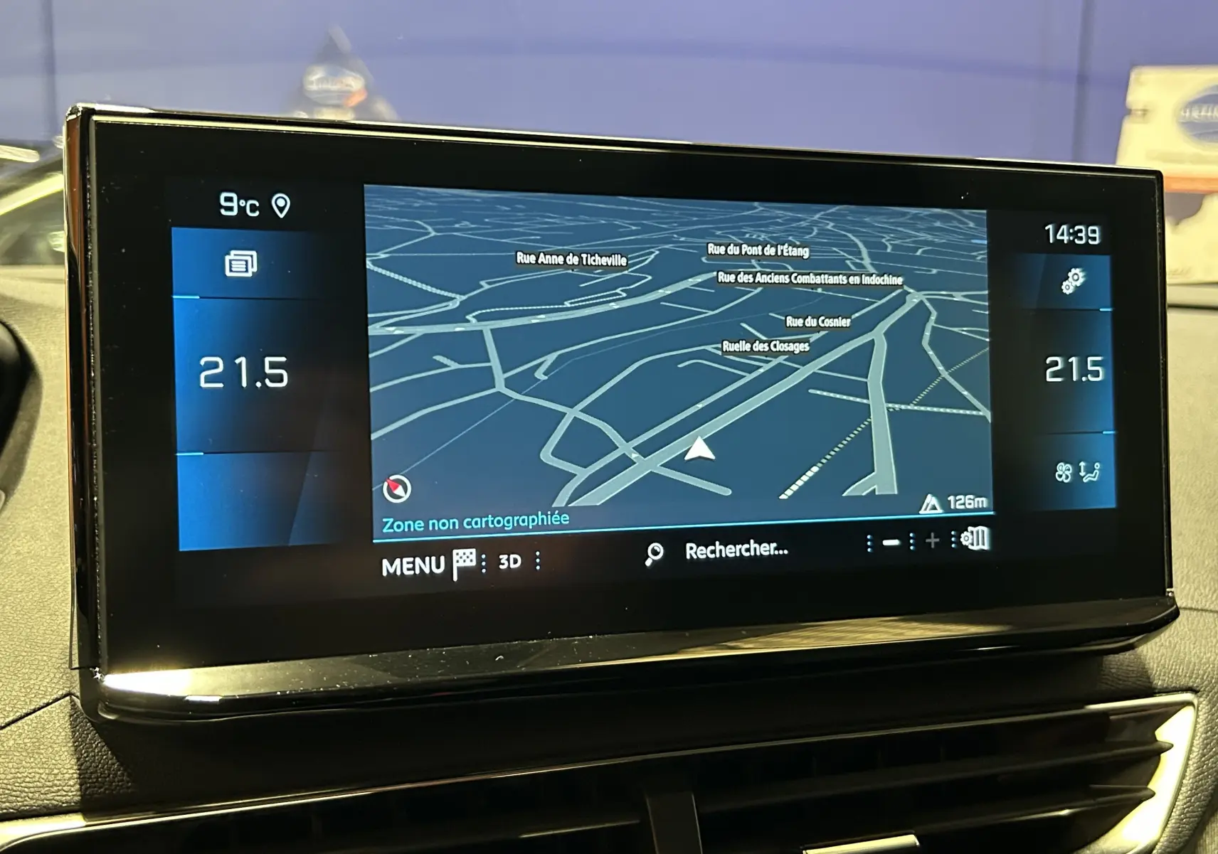 Écran tactile du GPS de la Peugeot 3008 Hybrid 2024 affichant une carte en 3D avec température intérieure à 21,5°C.