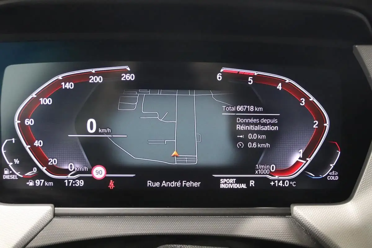 Tableau de bord numérique BMW Série 1 116d noir, affichant la navigation GPS et les compteurs en mode Sport Individual.