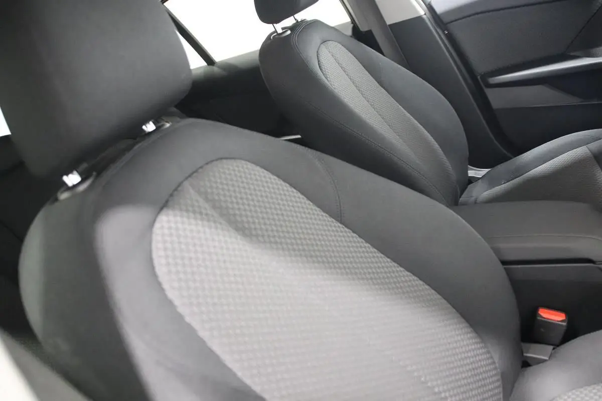 Gros plan sur les sièges avant en tissu gris et noir de la BMW Série 1 116d 2023, intérieur soigné et moderne.