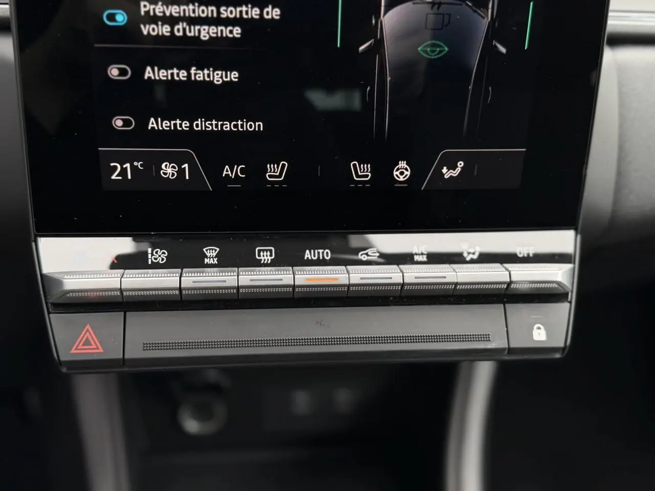 Détail du tableau de bord tactile du Renault Captur 2026 avec commandes climatisation et alertes sécurité visibles.